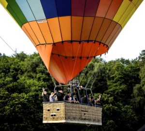 Kolorowy balon z pasażerami wznoszący się w powietrze